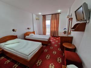 une petite chambre avec deux lits et une télévision dans l'établissement Hotel Coral, à Satu Mare 63 autres photos