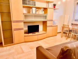 a living room with a flat screen tv in a book shelf at sky apartment a due passi dalla stazione in Collegno