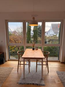 a table and chairs in a room with windows at Gemütliches Wohnen in Worms