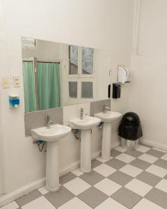 ein Badezimmer mit 3 Waschbecken und einem Spiegel in der Unterkunft Happy House Hostel in Santiago