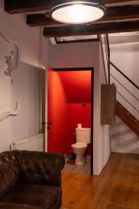 een woonkamer met een bank en een rode muur bij Maison 3 in Souvigny