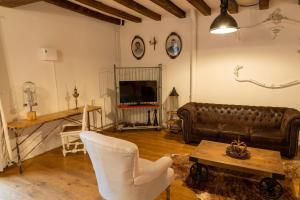 een woonkamer met een leren bank en een tafel bij Maison 3 in Souvigny