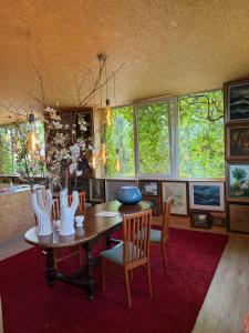 a dining room with a table and chairs and windows at kunstig appartement in Poelkapelle