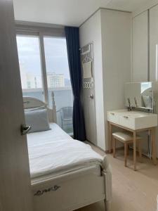 アンサンにあるHigh City view Room with Netflixのベッドと机と洗面台のある寝室