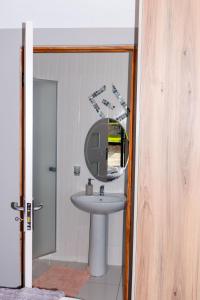 un baño con lavabo y espejo en @Home BnB, en Maseru