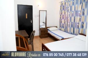 een kamer met 2 bedden, een tafel en een spiegel bij Aluvihare Residence in Matale