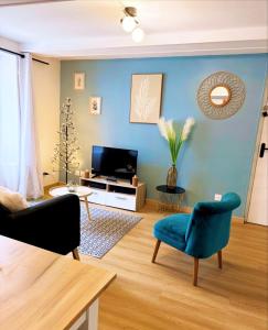 un soggiorno con pareti blu e TV di Le cosy du centre Dole a Dole