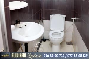 a bathroom with a white toilet and a sink at Aluvihare Residence in Matale
