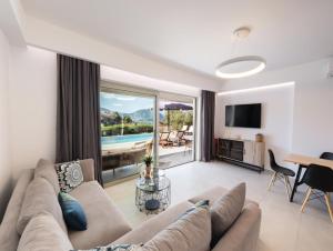 a living room with a couch and a table and a television at Tina by Vintage Travel in Spartokhórion