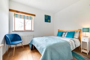 ein Schlafzimmer mit einem Bett und einem blauen Stuhl in der Unterkunft Churn Barn in Chinley