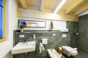 a bathroom with two sinks and a toilet at Ferienhaus Blauer Vogel - kostenfreie Saunanutzung in Prägraten