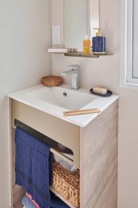 Camping La Vallée في أولغات: حمام به حوض غسيل مع منشفة تحته