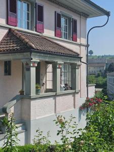 Un edificio con una ventana con persianas rojas. en Sunnegg, en Huttwil
