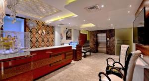 a restaurant with a bar with chairs in a room at Maya The Forest Resort in Rāmnagar