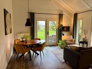 a living room with a wooden table and chairs at IJsselgoud in Zwolle