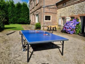 a ping pong table in front of a building at Chambres à la campagne La Tuilerie in Prêtreville