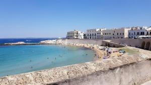 una spiaggia con persone nell'acqua e negli edifici di Dimore di Matilde - Mare Fuori a Gallipoli Altre 13 foto
