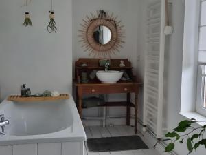 a bathroom with a sink and a tub and a mirror at Chambres à la campagne La Tuilerie in Prêtreville +48 photos