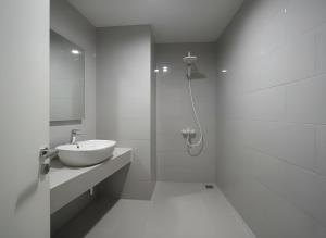 Un baño blanco con lavabo y ducha en Apartemen Anderson 03 Pakuwon mall Luxury Studio Apartment Connecting Mall, Pool & City View, en Surabaya