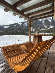 a wooden hammock on a deck with a table at Ferienhaus Messner in Hohentauern