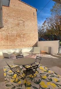 a table and chairs on a rug in front of a brick building at Le Léon in Saint-Léon