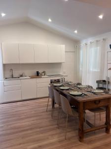 a kitchen with a wooden table and white cabinets at Le Léon in Saint-Léon