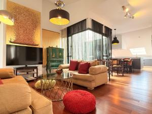 a living room with a couch and a table at Ático en Plaza de la Constitución 3 bedrooms in Málaga