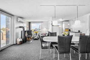 Una cocina y un comedor con mesa y sillas. en FY403-Asperup-Eskelundsvaenget-1, en Voldby