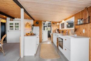 VoldbyにあるFY402-Asperup-Eskelundsvaenget-9の白いカウンターと木製の天井が備わるキッチン