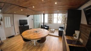 a large room with a wooden table and a television at Loft industriel - hyper centre cambrai in Cambrai