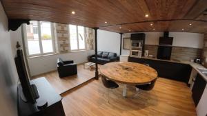 a living room with a wooden table and a kitchen at Loft industriel - hyper centre cambrai in Cambrai +11 photos