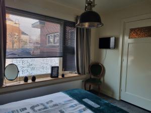 a bedroom with a bed and a window with a mirror at De Oude Bakkerij in Onderdendam