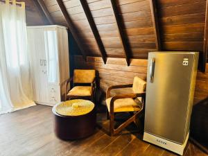a kitchen with a refrigerator and two chairs and a table at Soluna Cove luxury Cabanas Hikkaduwa in Hikkaduwa