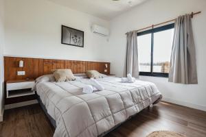 Colonia ChapadmalalDread Shack Nodo Norte 2 - Casa en Complejo Zona Santa Isabel, Chapa Para 4 PAX Con Parrilla - Hola Sur的一间卧室，配有一张大床和一扇大窗户。