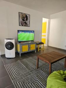 サンタンヌにあるAppartement spacieux avec vue sur mer à Sainte-Anneのリビングルーム(薄型テレビ、テーブル付)