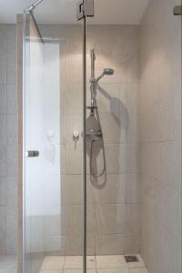 una doccia con una porta in vetro in un bagno di Kata sea View appartmens a Ban Kata