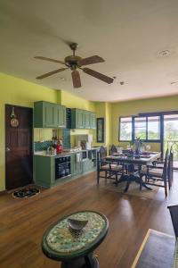 AoNang BeachFront 2BR Night market في شاطيء آونانغ: مطبخ وغرفة معيشة مع طاولة ومروحة سقف