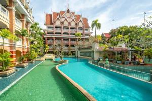 AoNang BeachFront 2BR Night market في شاطيء آونانغ: فندق به حمام سباحة أمام المبنى