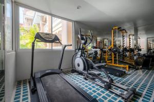 AoNang BeachFront 2BR Night market في شاطيء آونانغ: صالة ألعاب رياضية بها عدة دراجات تمارين في الغرفة