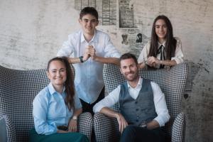 un grupo de tres personas sentadas en sillas en B&B Boutiquehotel Clara, en Brunico
