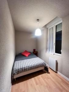Un dormitorio pequeño con una cama y una ventana. en le 2 - Château - Ville, en Château-Chinon