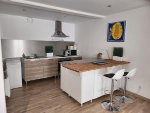a kitchen with a counter and two bar stools at Spacieux Studio Sushi - 1 lit double - Rue calme- Centre ville in Charleville-Mézières