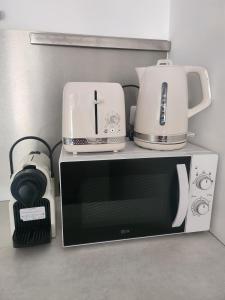 a microwave with a coffee maker and a toaster at Spacieux Studio Sushi - 1 lit double - Rue calme- Centre ville in Charleville-Mézières