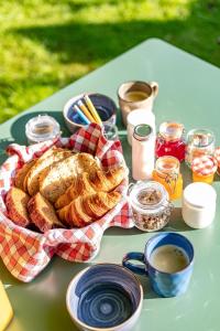 a table with a basket of bread and jars of jam at La Casa du Vau - Tiny House in Bussy-le-Grand