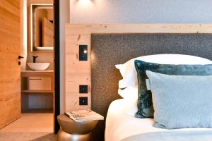 a bedroom with a bed with a blue pillow and a sink at Chalet Mademoiselle in Les Allues