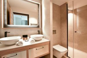 a bathroom with two sinks and a toilet and a mirror at Chalet Mademoiselle in Les Allues