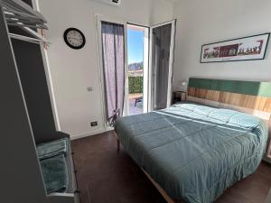 a bedroom with a bed and a clock on the wall at Casa SERGE vista mare con ampio terrazzo privato in Bergeggi
