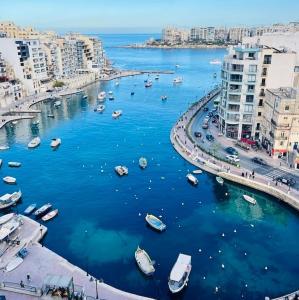 Taʼ XbiexCozy 1 Bedroom Maisonette near Ta Xbiex Marina的港口景色，水里停着小船