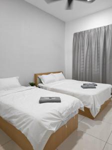 Dos camas una al lado de la otra en una habitación. en Cozy Haven 暖心居, en Simpang Ampat