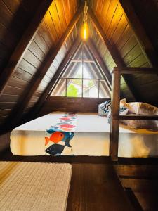 Cama en habitación con ventana en el ático en Soluna Cove Cabanas Hikkaduwa, en Hikkaduwa